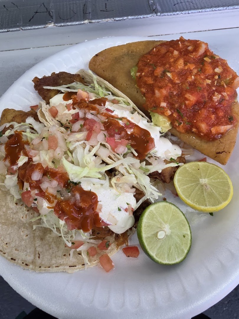 Outdoor seating at a seafood taco truck.